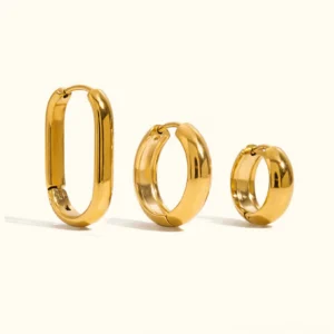 18K gold hoop earrings trio set flat lay view featuring three distinct sizes and styles on plain background