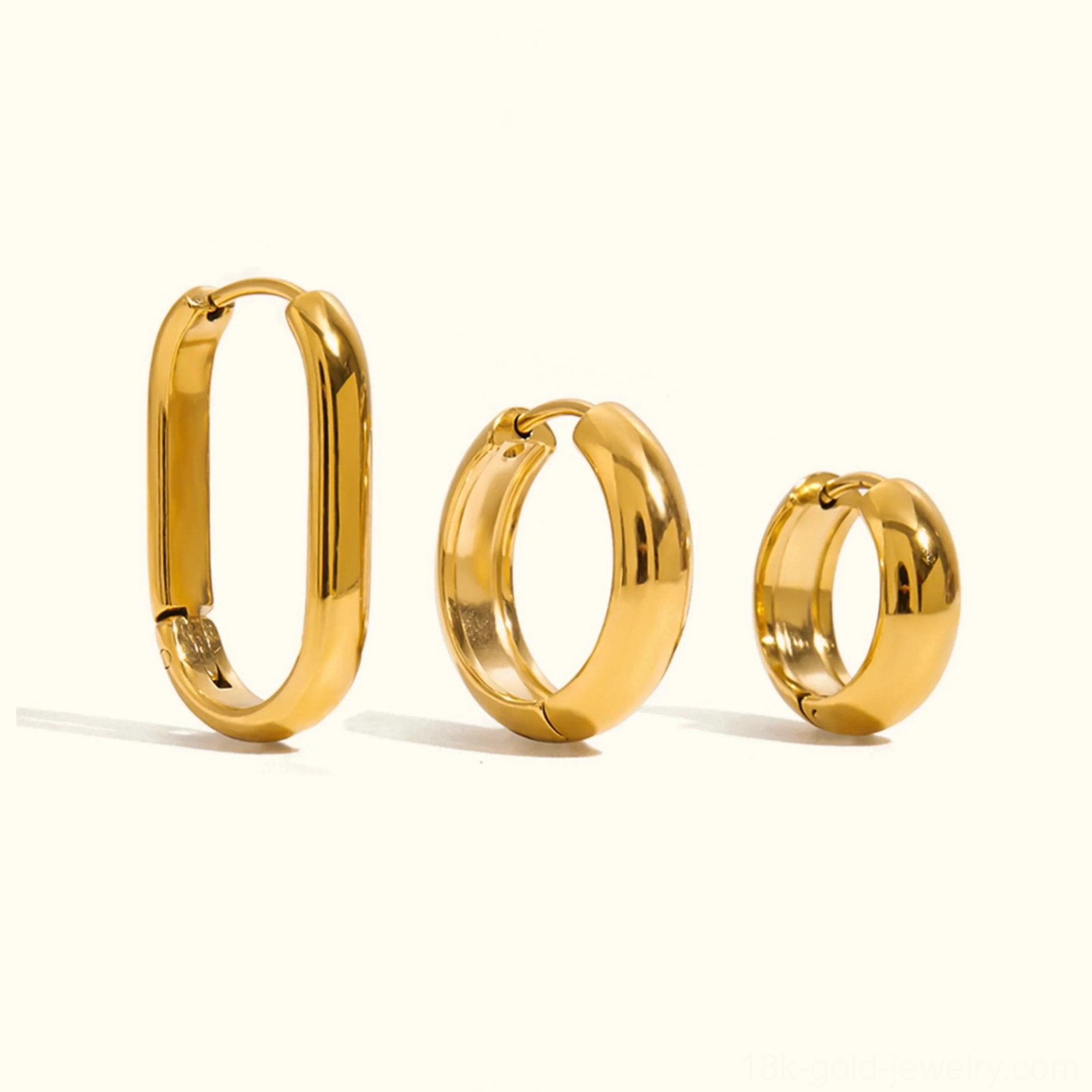 18K gold hoop earrings trio set flat lay view featuring three distinct sizes and styles on plain background