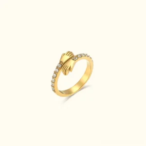 18K gold hug ring with cubic zirconia front view - three dimensional hugging hands design with paved rhinestones on matte gold band