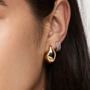 18K gold teardrop studs close-up on model ear side profile elegant fit