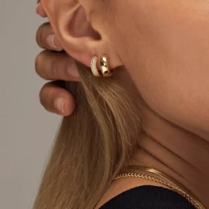 Gold huggie earrings worn on ear comparison pavé gemmed vs smooth solid gold styles