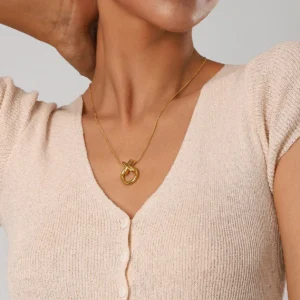 delicate gold knot pendant necklace worn on model close-up front view minimalist jewelry