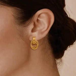 18K gold knotted hoop earrings worn on model ear side close-up view pulled back dark hair how to wear