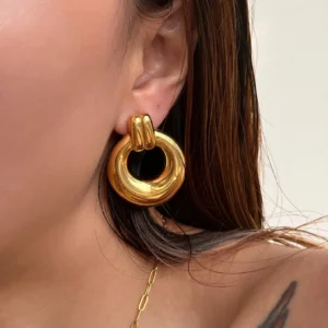 18K gold knotted earrings worn on earlobe close-up side view woman with long brown hair smooth polished gold surface