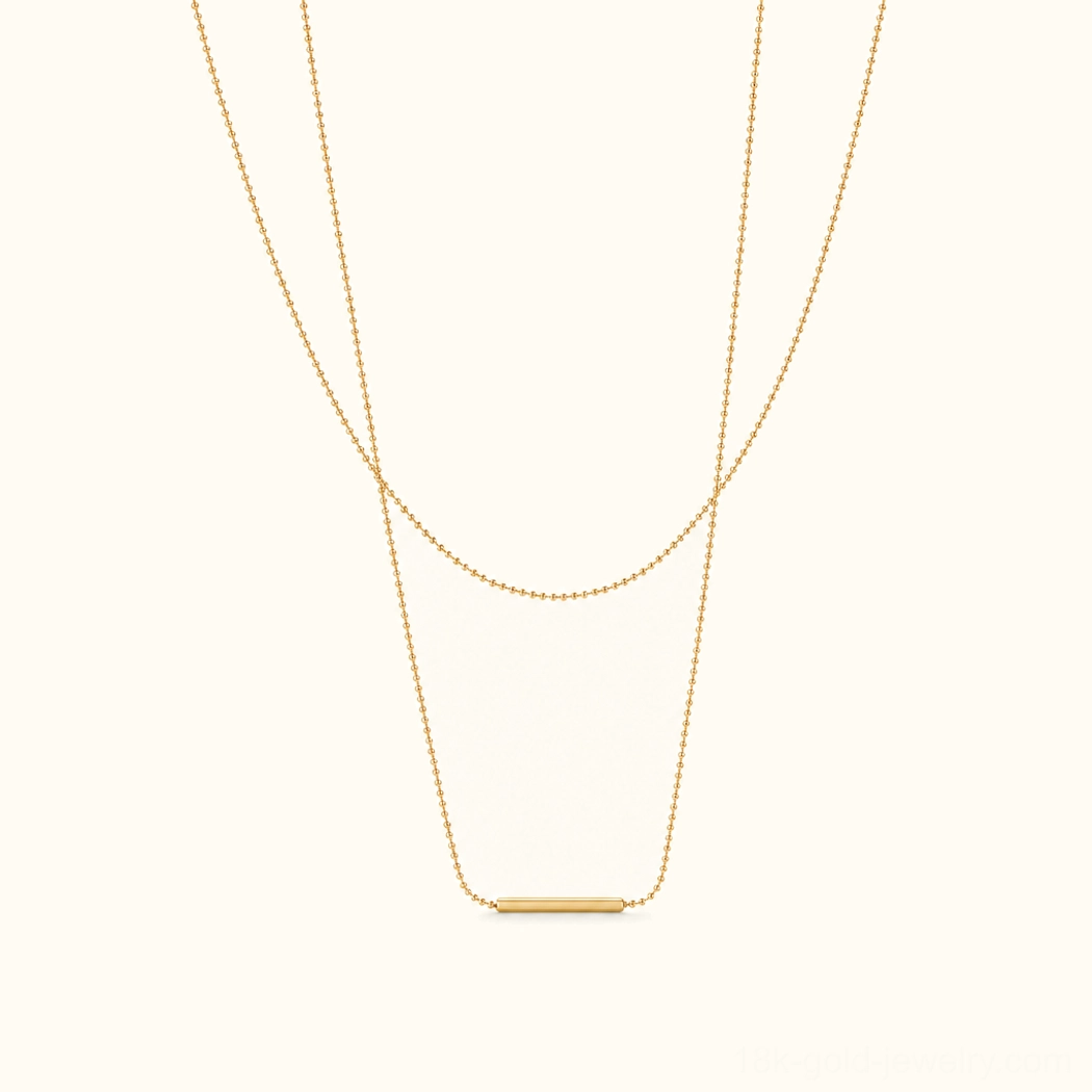 18K Gold Layered Bar Necklace flat lay front view featuring dual staggered chains with polished gold bar pendant