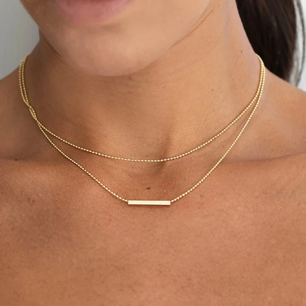 18K Gold Layered Bar Necklace closeup on neck showing delicate beaded chains and polished gold bar pendant detail