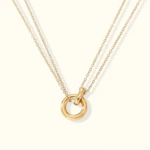 18K gold layered circle pendant necklace flat lay front view with interlocking circular charm and polished gold finish