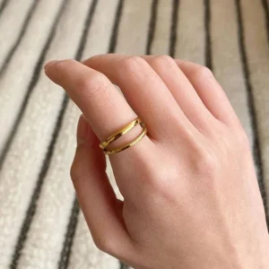 Gold stacked double band ring on female hand, close-up side view showing fit and finish detail