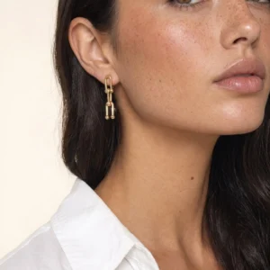18K gold link drop earrings worn on ear close-up showing elegant single link design with smooth polished gold finish on woman model