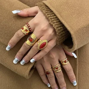 Stacked 18K gold marquise rings worn on hands with silver French manicure, vintage gold jewelry collection display