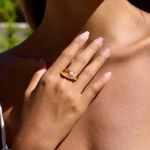 Stackable 18K gold marquise diamond rings worn on female hand close-up - delicate marquise cut stone with accent details