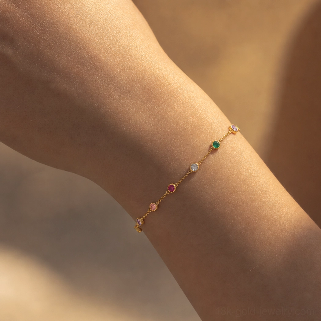 18K gold multicolor gemstone bracelet worn on medium-toned arm featuring slim gold chain and bezel-set round mixed precious crystal stones lifestyle photo