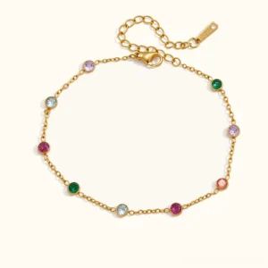 18K gold multigemstone bracelet flat lay overhead view featuring ten bezel-set colorful crystals including emerald amethyst aqua ruby and blush tones on adjustable gold chain