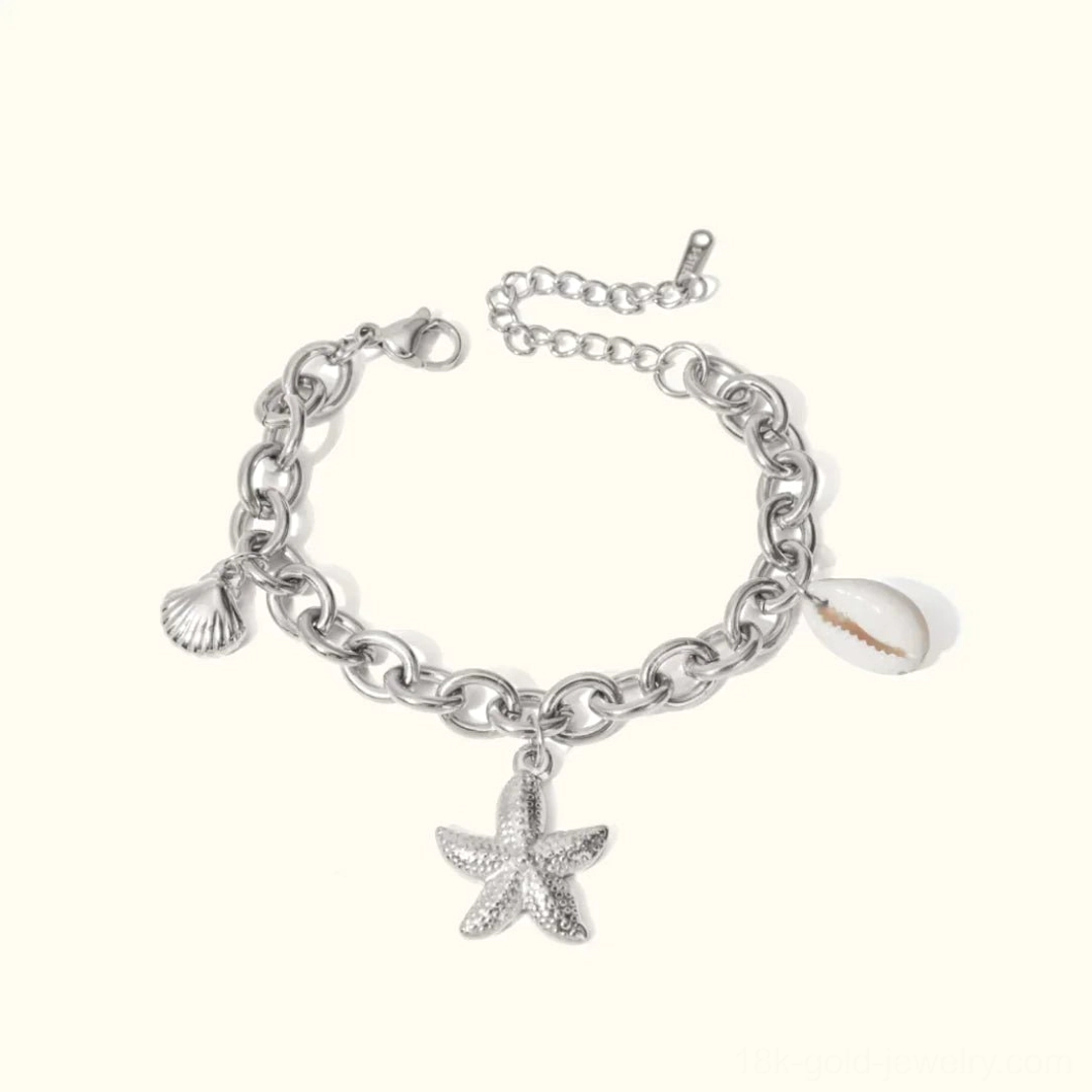 18k gold ocean-themed charm bracelet white background starfish shell pearl flat lay
