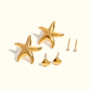 Complete 18K gold ocean earring bundle flat lay display with all three pieces starfish shell and crystal studs on white background polished finish