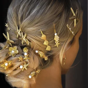 18K gold ocean-themed hair pin with starfish shell and pearl charm worn in blonde updo hairstyle back lateral view
