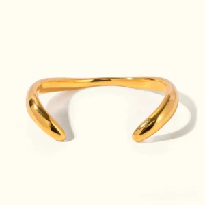 18K gold open cuff bangle flat lay front view polished minimalist curved design luxury bracelet