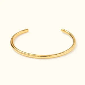 18K gold open cuff bangle flat lay top view polished minimalist C-shaped bracelet design