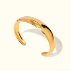 18K gold open cuff bangle top-down flat lay view showcasing polished smooth wide curved band with lustrous finish