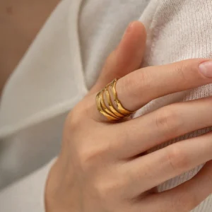 18K gold adjustable ring worn on female hand, close-up shot showing wavy layered band structure and polished gold finish