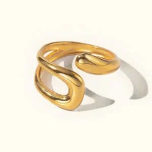 18K gold open cuff ring flat lay top-down view polished curves fluid silhouette studio background