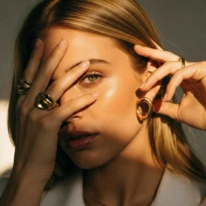 18K gold hoop earrings worn on model minimalist stacking design studio portrait