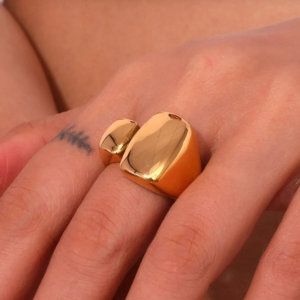 Oversized 18K Gold open ring with warm golden tone on tattooed finger, close-up detail view of irregular block shape and reflective polished surface