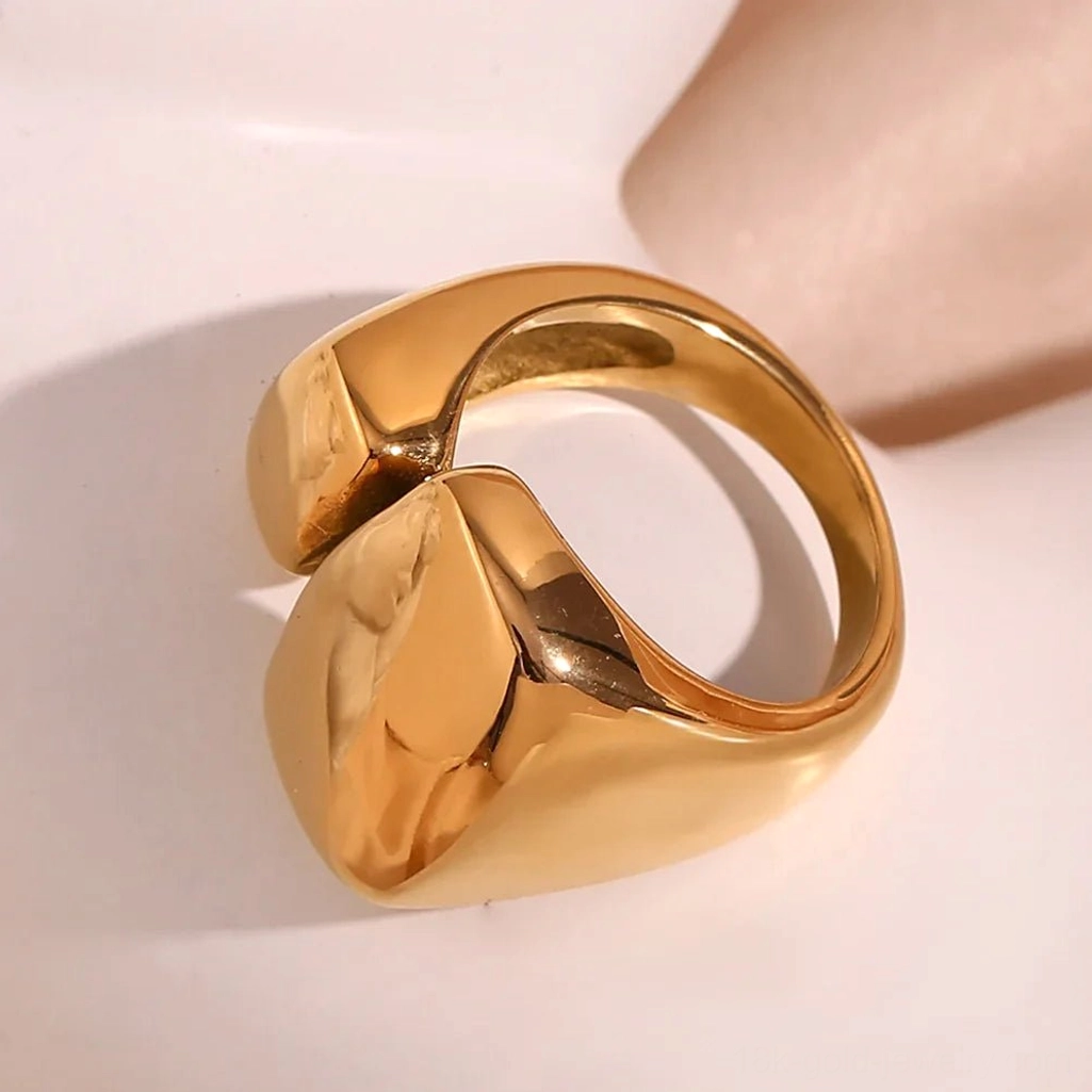 18K Gold open wrap band geometric ring with polished finish on neutral soft background, side flat lay highlighting irregular block shape and smooth texture
