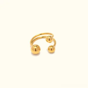 18K gold orbit ring with three polished spheres in flat lay top-down view showcasing the sculptural split band design and mirror-bright finish