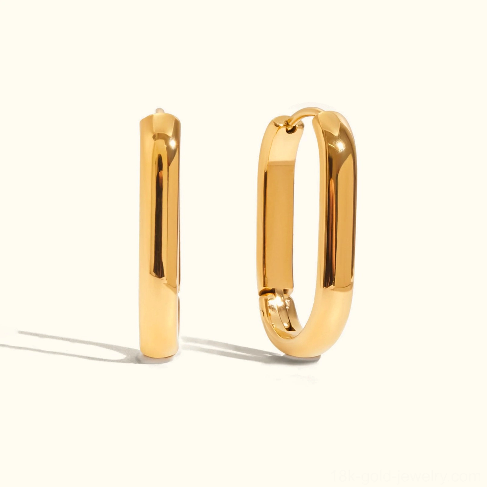 Oval rectangular 24mm gold hoop earrings flat lay displaying hinged clasp and polished gold finish