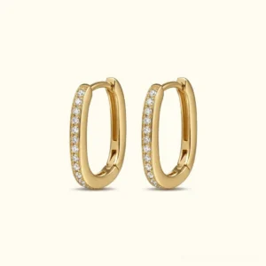 18K gold oval huggie hoop earrings with pavé cubic zirconia front flat lay product shot on neutral background