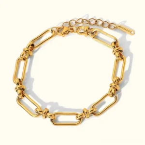 18K gold paperclip chain bracelet with rectangular links, polished finish, flat lay view showcasing delicate design and adjustable extender