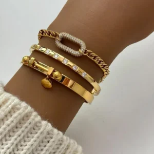 Stackable 18K gold bracelets worn on wrist - multiple stacking styles with curb chain and stone paved design on dark skin tone