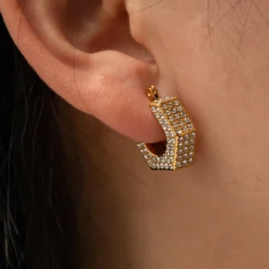18K gold crystal pavé huggie earring worn on ear, close-up view demonstrating snug fit and sparkly rhinestone detailing on earlobe