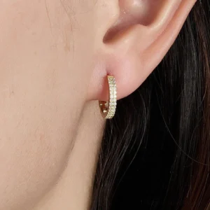 huggie hoop earrings with pavé cubic zirconia worn on model ear close-up side view