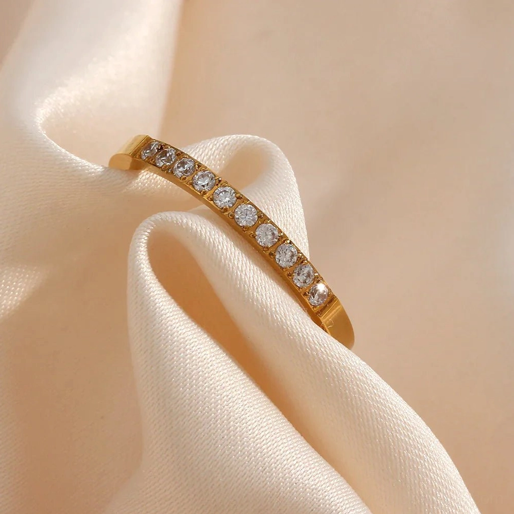 Full pavé 18K gold ring poly style side close-up view with zirconia stones on silk fabric background