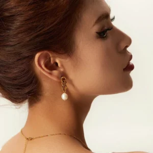 18K gold pearl drop earrings worn on model profile side view showing elegant gold chain stud with single pearl pendant on female ear