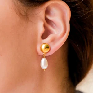 Close-up side view of 18K gold pearl drop earrings worn on ear showing delicate gold stud and elongated pearl dangle
