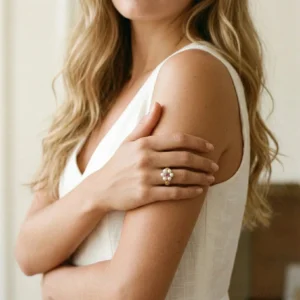 18k gold pearl floral ring worn on hand - dainty elegant design featuring white freshwater pearls on blonde woman model
