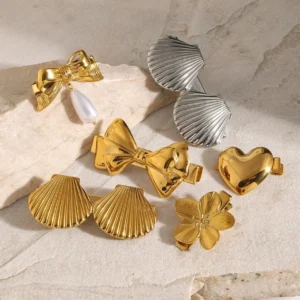 Collection of assorted metal hair clips in gold and silver with pearl shell flower heart designs marble background