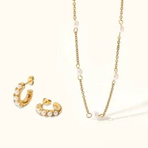 18K gold pearl huggie earrings and pearl station necklace luxury jewelry bundle flat lay