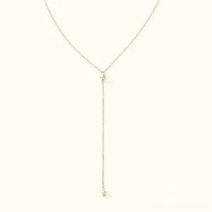 18K gold pearl lariat necklace flat lay product display with Y-shaped drop design and two lustrous freshwater pearls on white background