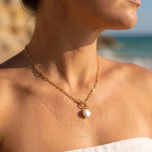 Woman wearing 18K gold freshwater pearl necklace at seaside beach outdoor setting with twisted gold chain