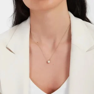 18K gold pearl necklace worn on model at collarbone showing elegant pendant placement and minimalist design