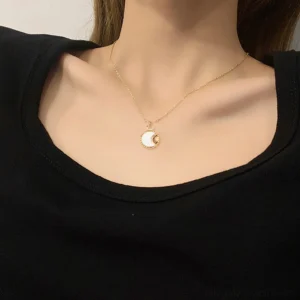 18K gold pearl necklace worn on model neck collarbone close-up detail shot - dainty gold chain with round white shell pendant showing elegant draping