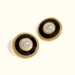 18K gold pearl stud earrings with black enamel and twisted gold rim, flat lay product shot on white background, vintage modern design