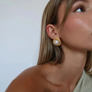 18K gold pearl stud earrings worn on female model ear side close-up view minimalist gold frame white pearl
