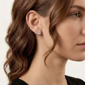 18K gold cubic zirconia stud earrings worn on ear close-up side view with model showing snug fit on earlobe
