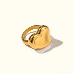 18K gold puffy heart ring - flat lay top-down view showing polished glossy gold finish and solid heart silhouette on plain background