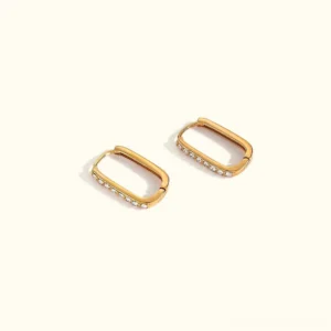 18K gold rectangular hoop huggie earrings flat lay, champagne gold finish with crystal pavé embellishment, top-down view on beige background